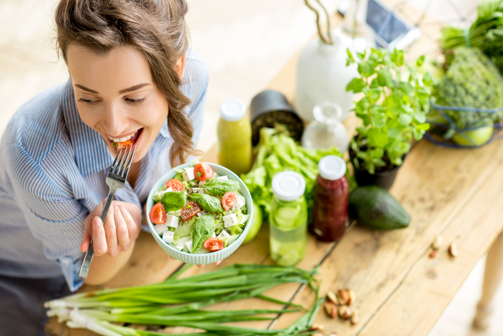 happy woman eating a microbiome fertility friendly healthy salad